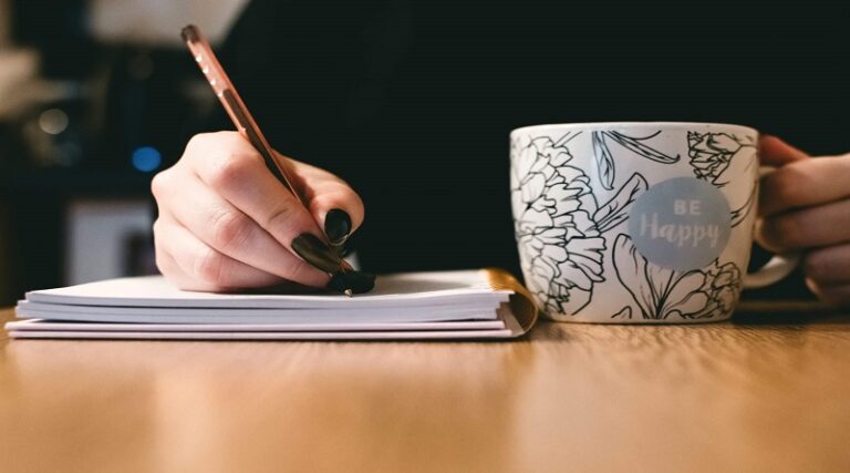 629146c1c7040304df9e1083_Writer-with-Mug-scaled